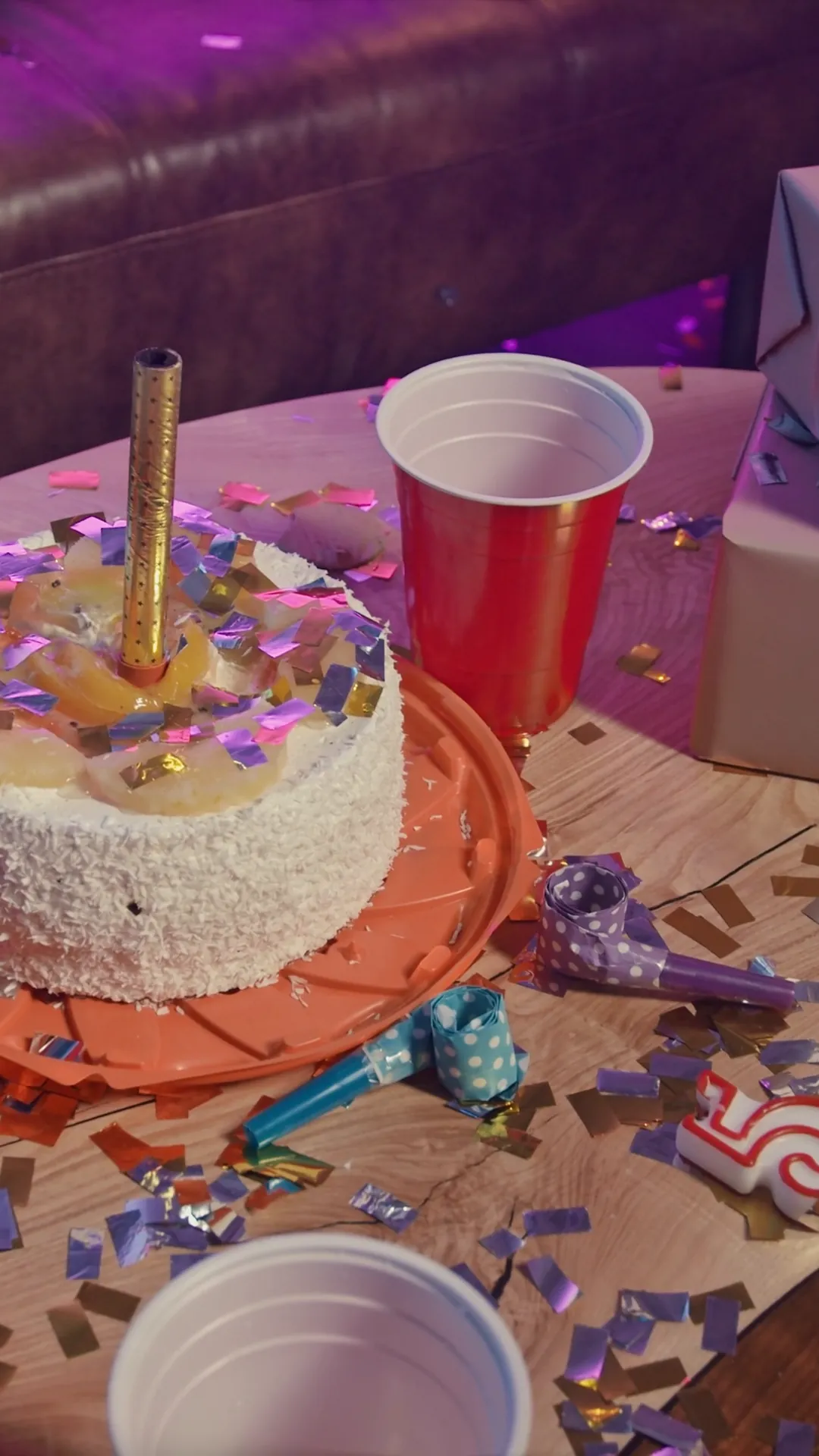 Pozadina za pozivnicu za rođendan, torta sa svećicom, konfete i čaše na stolu